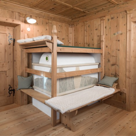 Holzraum mit einem traditionellen Bauernofen und Holztüren mit schwarzen Beschlägen